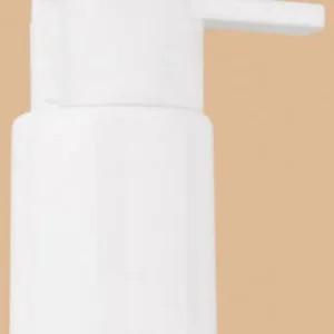 Close-up of a white plastic lotion pump dispenser, also known as a white beak pump, shown against a light tan background.