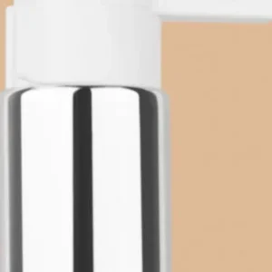 Close-up of a white and silver lotion pump dispenser head against a tan background.